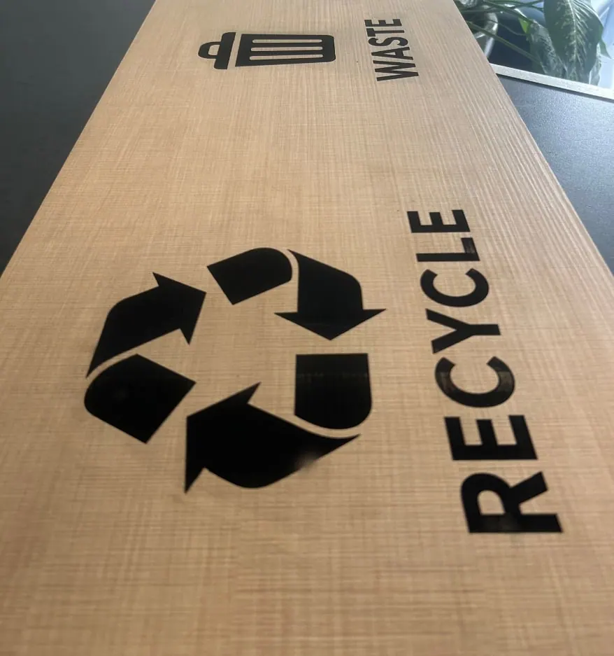 Señal de reciclaje sobre lámina con acabado de madera