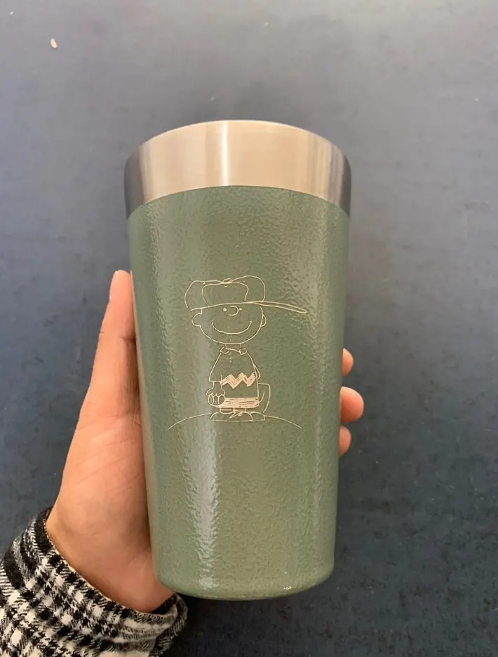 Vaso térmico verde con una ilustración grabada