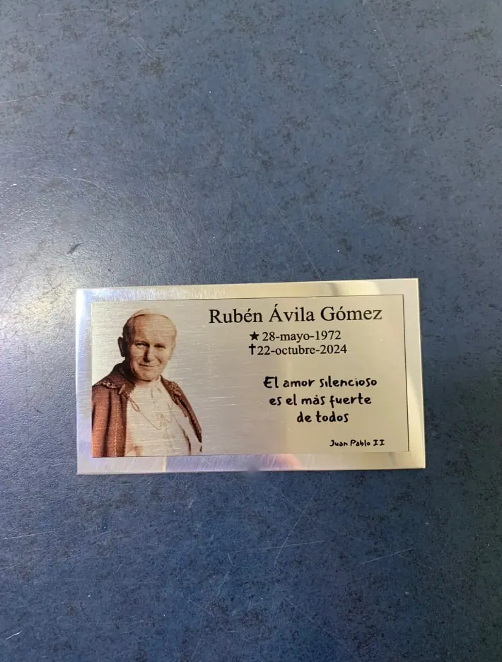Placa plateada con una imagen y una dedicatoria grabadas